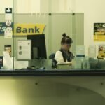 1. Sretna umirovljenica pregledava bankovne dokumente za stolom.